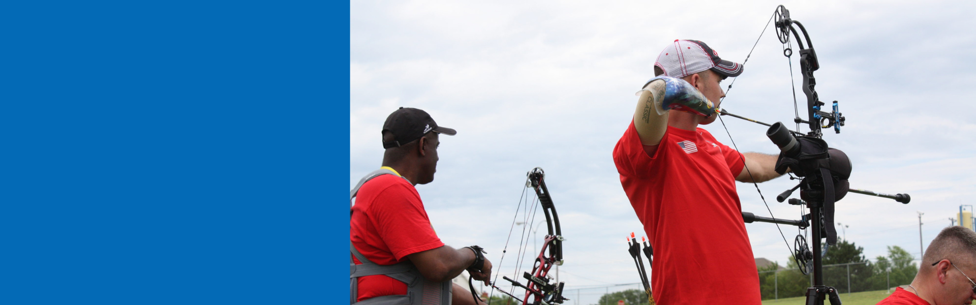 a person with a prosthetic arm is aiming an archery bow and preparing to release it