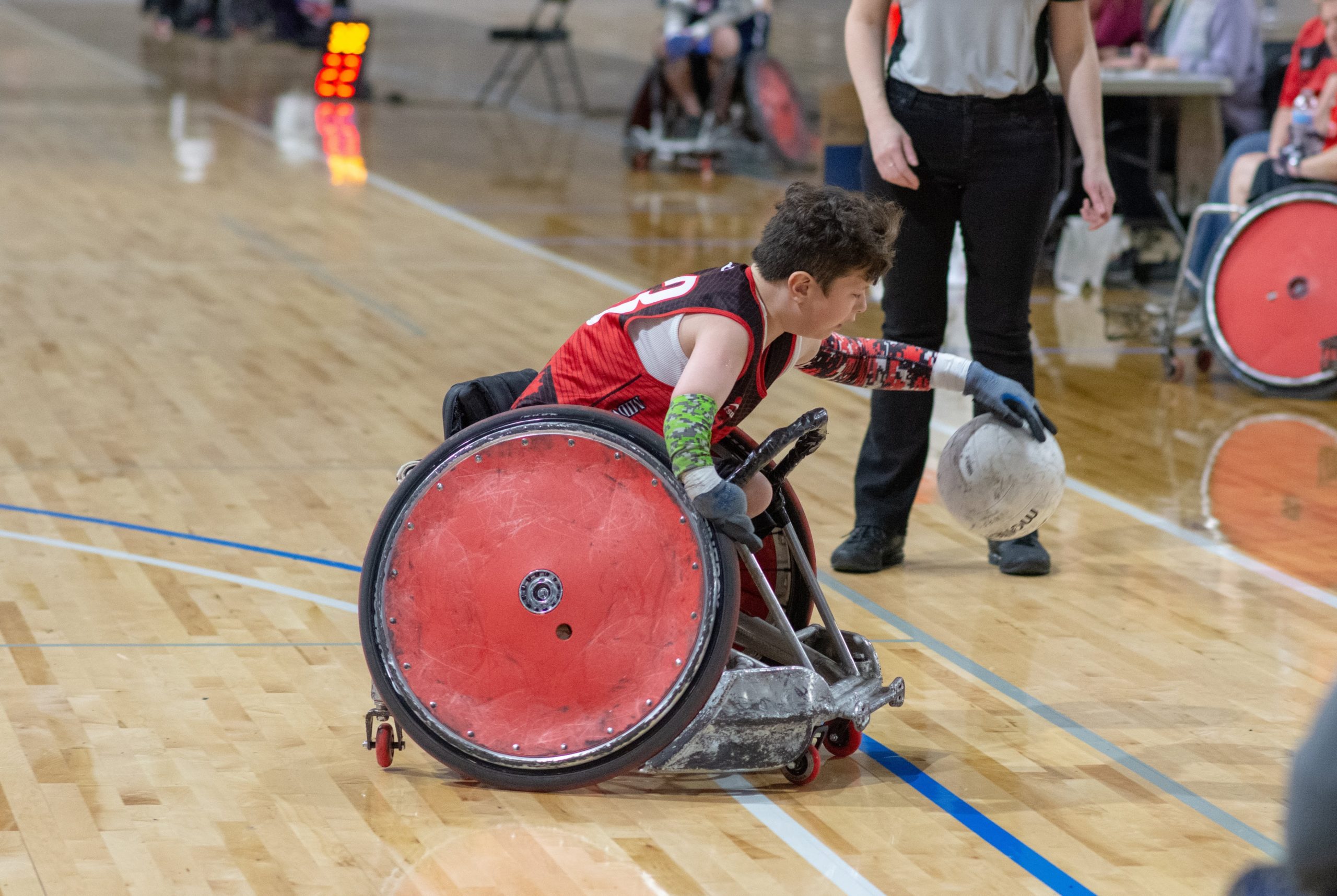 Athlete in a wheelchair bouncing a ball off the ground