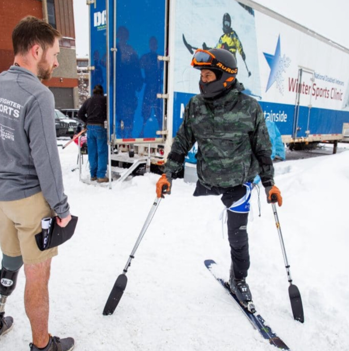 Male skier with right leg amputation talking to another athlete