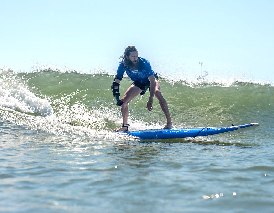 Athlete with right arm amputation surfing