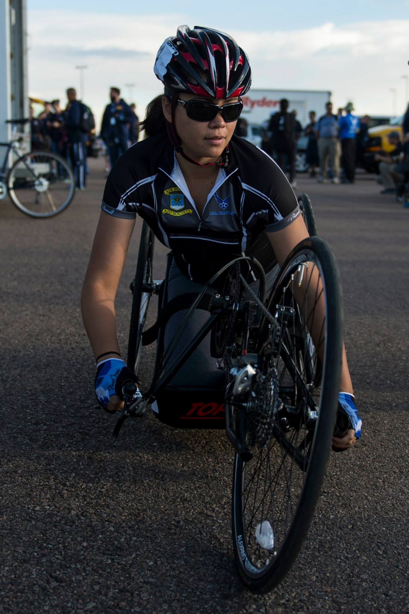 Female athlete in racing wheelchair looking off to the side