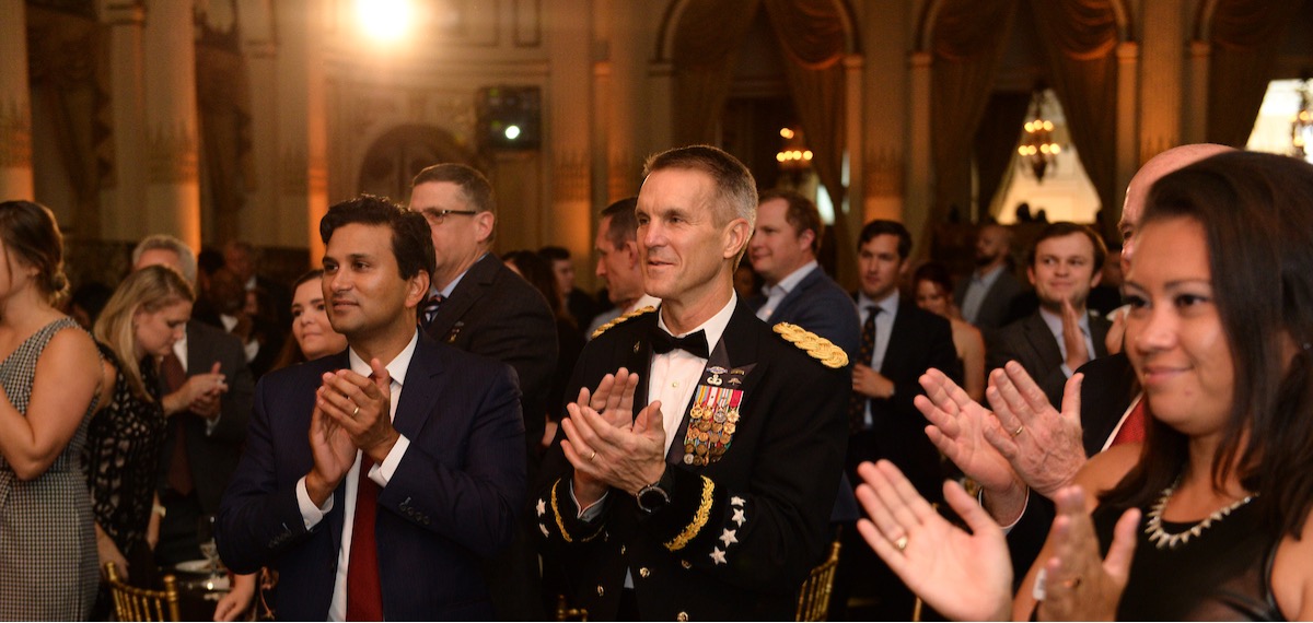 group of people in formal attire applauding