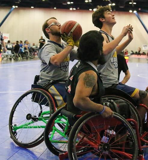 Three athletes playing wheelchair basketball