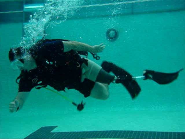 Male athlete under water scuba diving with left leg amputation and prosthetic