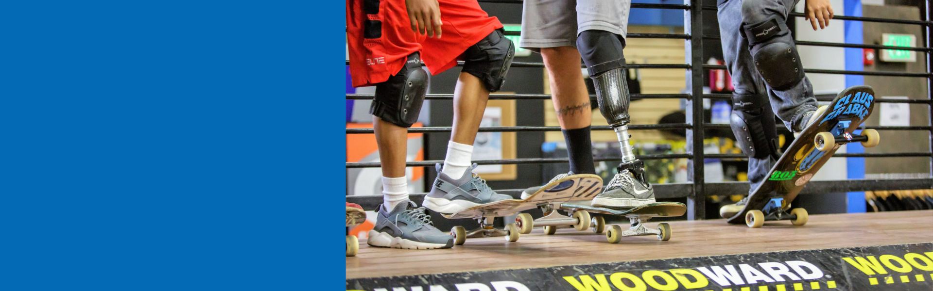 close up of peoples feet, some fully abled, others with prosthetics and all standing on skateboards about to go down a ramp