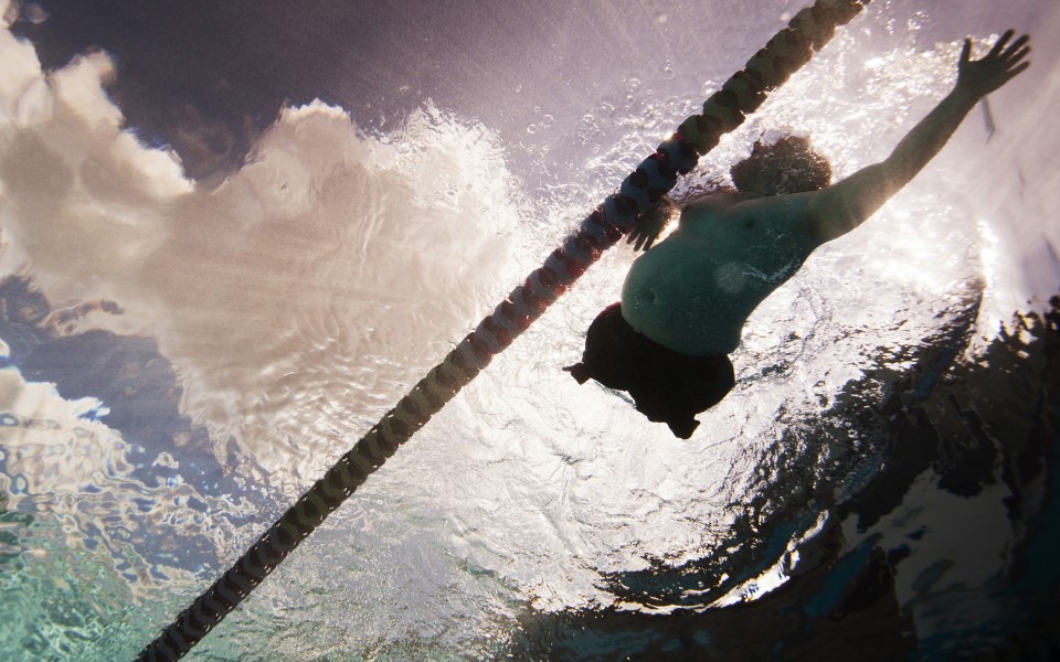 Picture taken from under water of a male athlete without legs swimming