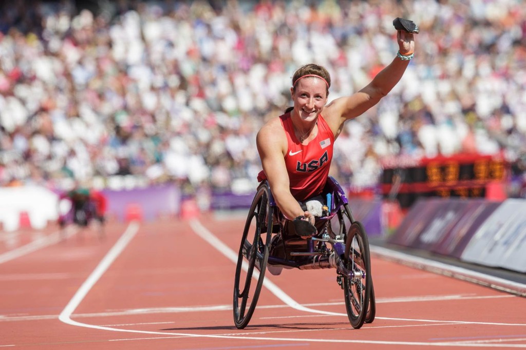 Female athlete in racing wheelchair celebrating