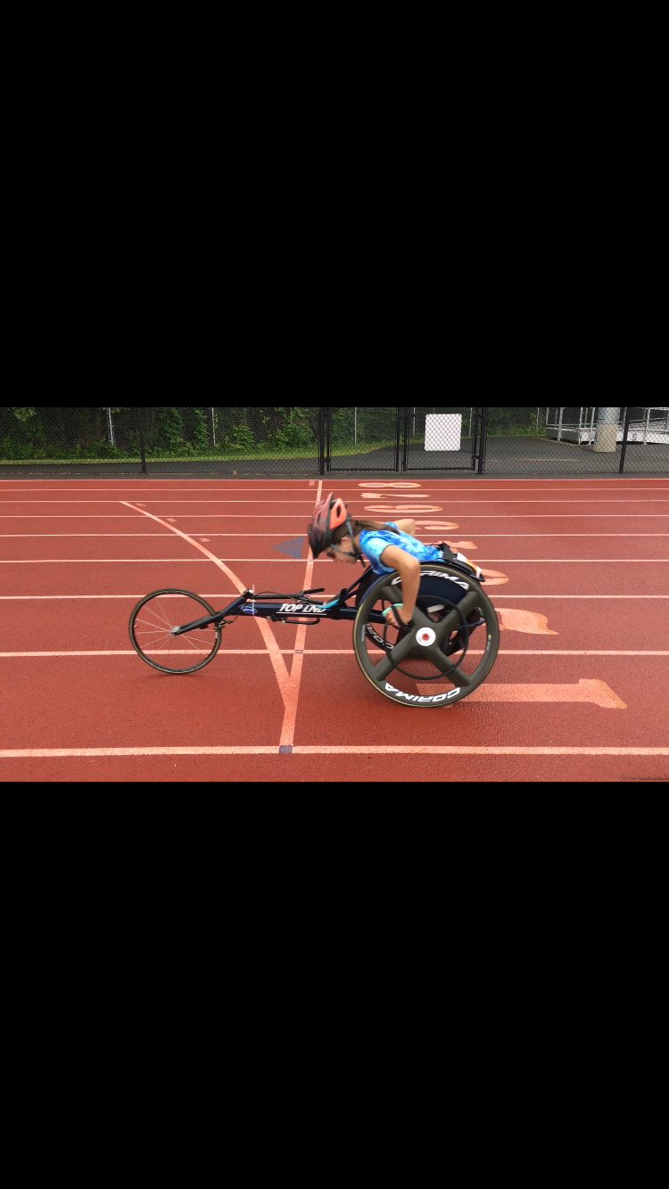 Female athlete on a track using a racing wheelchair
