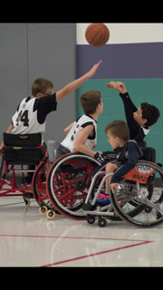 Group of young boys in wheelchairs playing wheelchair basketball