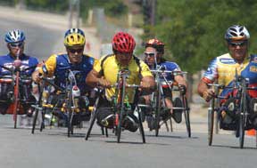 Group of male athletes competing in hand cycling race