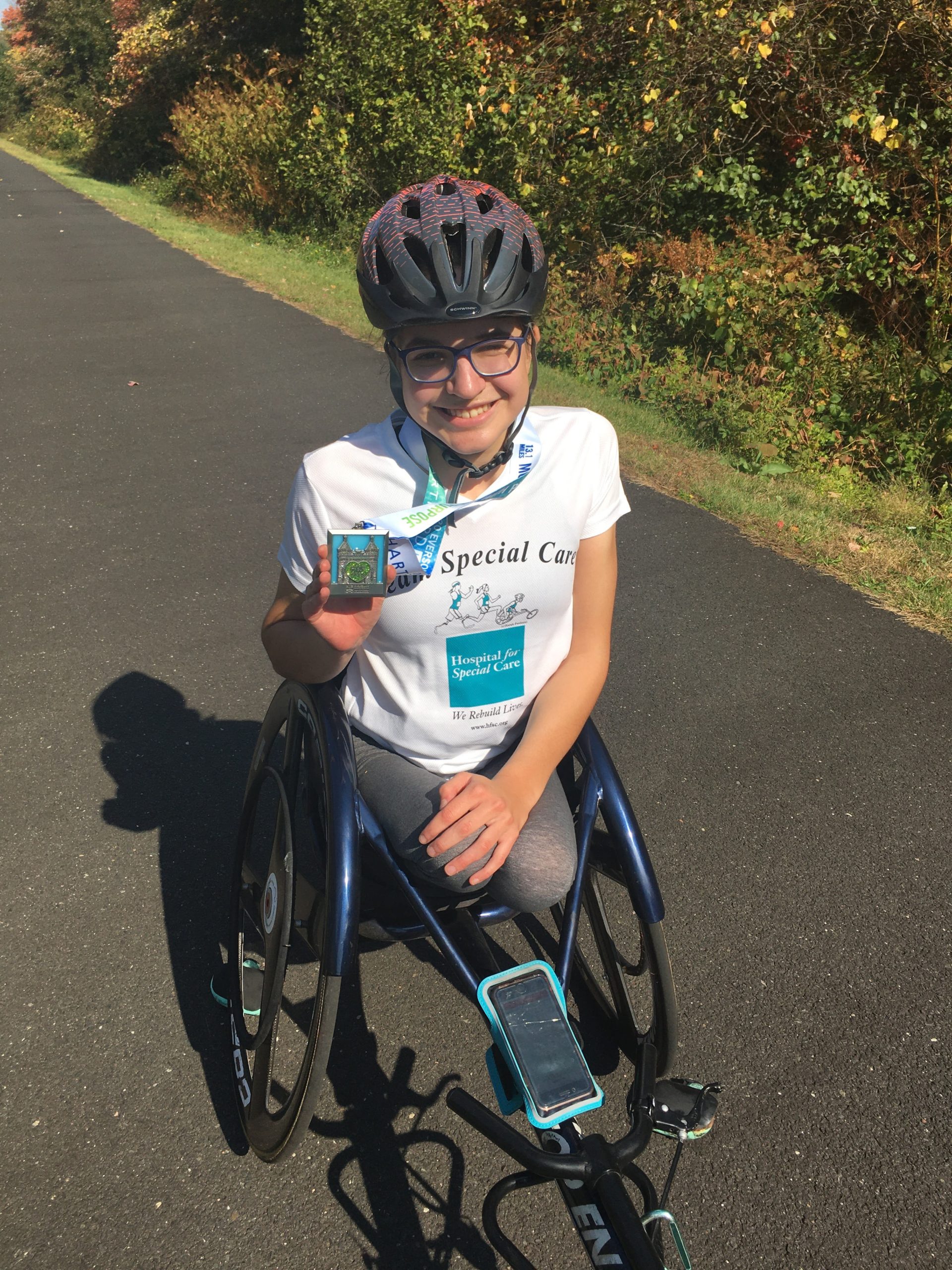 Female athlete in a racing wheelchair smiling at the camera