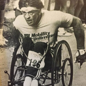 black and white photo of male athlete in a wheelchair racing