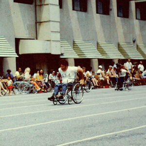 Athletes racing in wheelchairs with onlookers