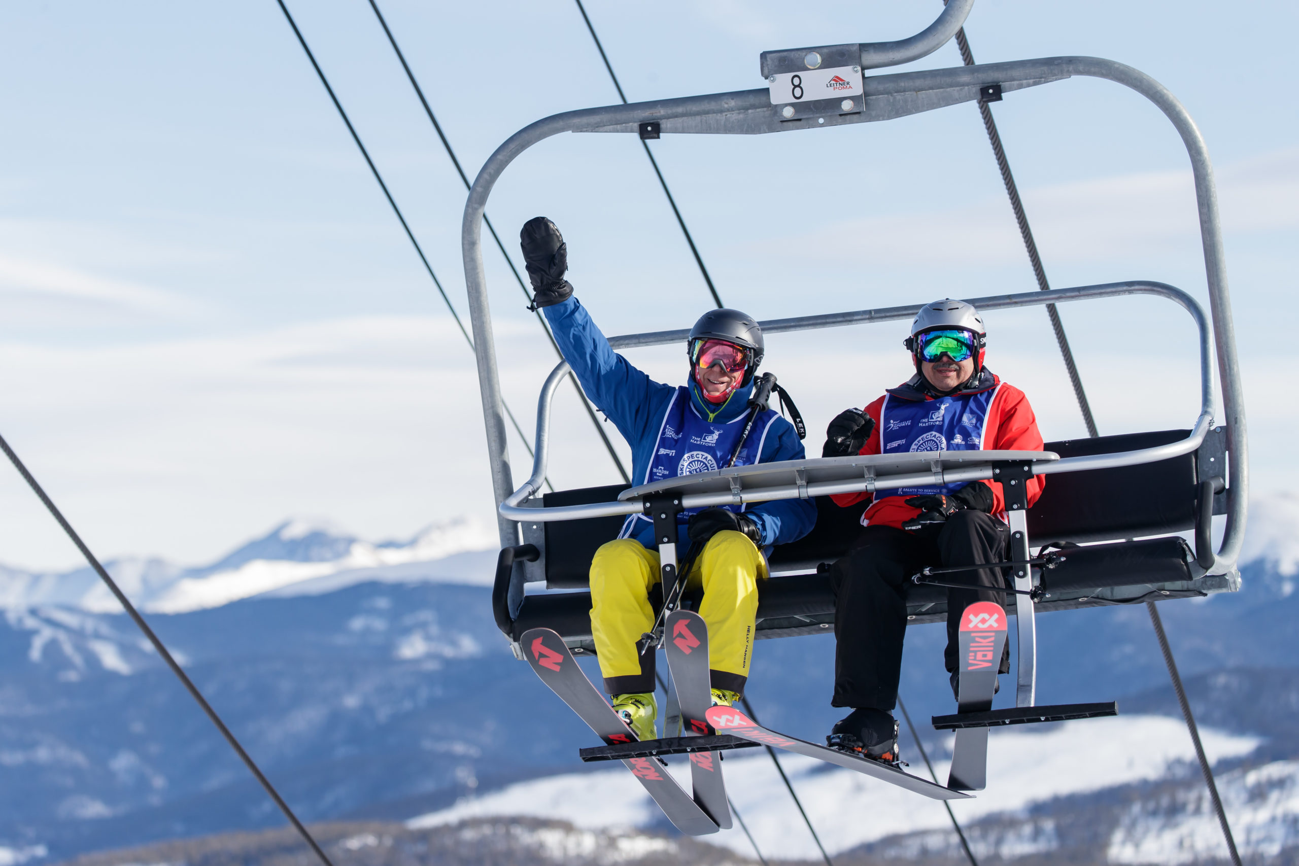 Two Ski Spec athletes on ski lift waving