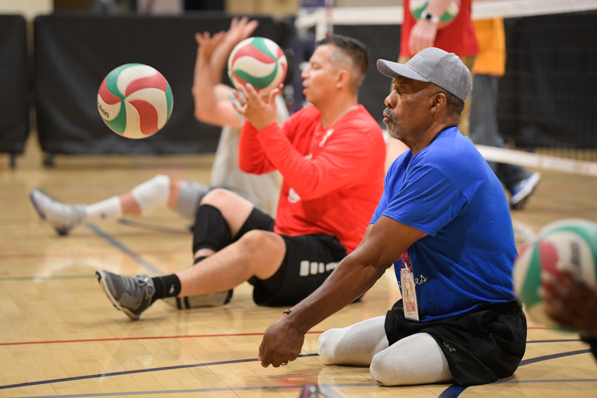 Three disabled athletes participating in seated volleyball.