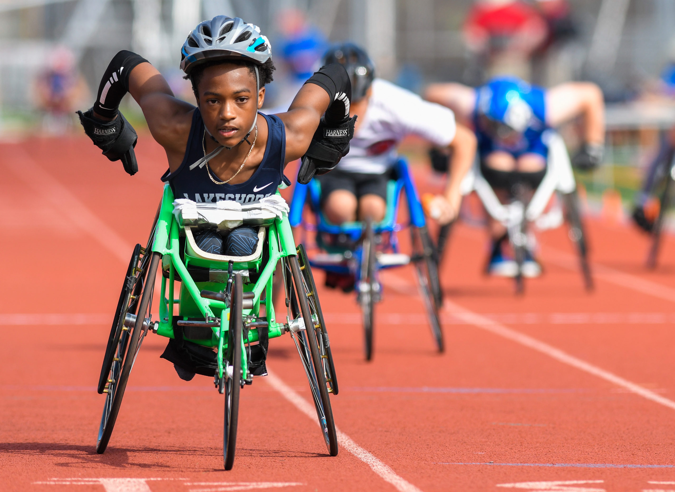 Male athlete in racing chair participating in track and field event at junior nationals.