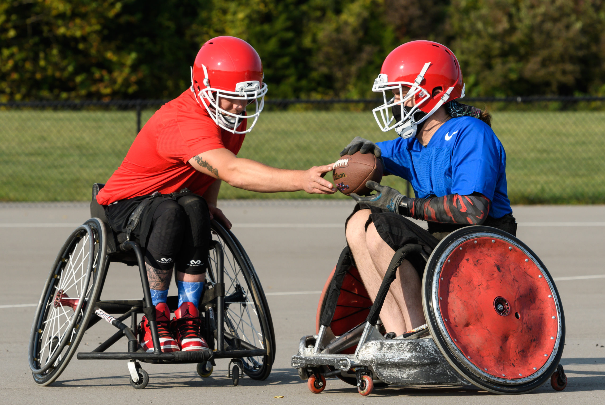 Two wheelchair football athletes grabbing football