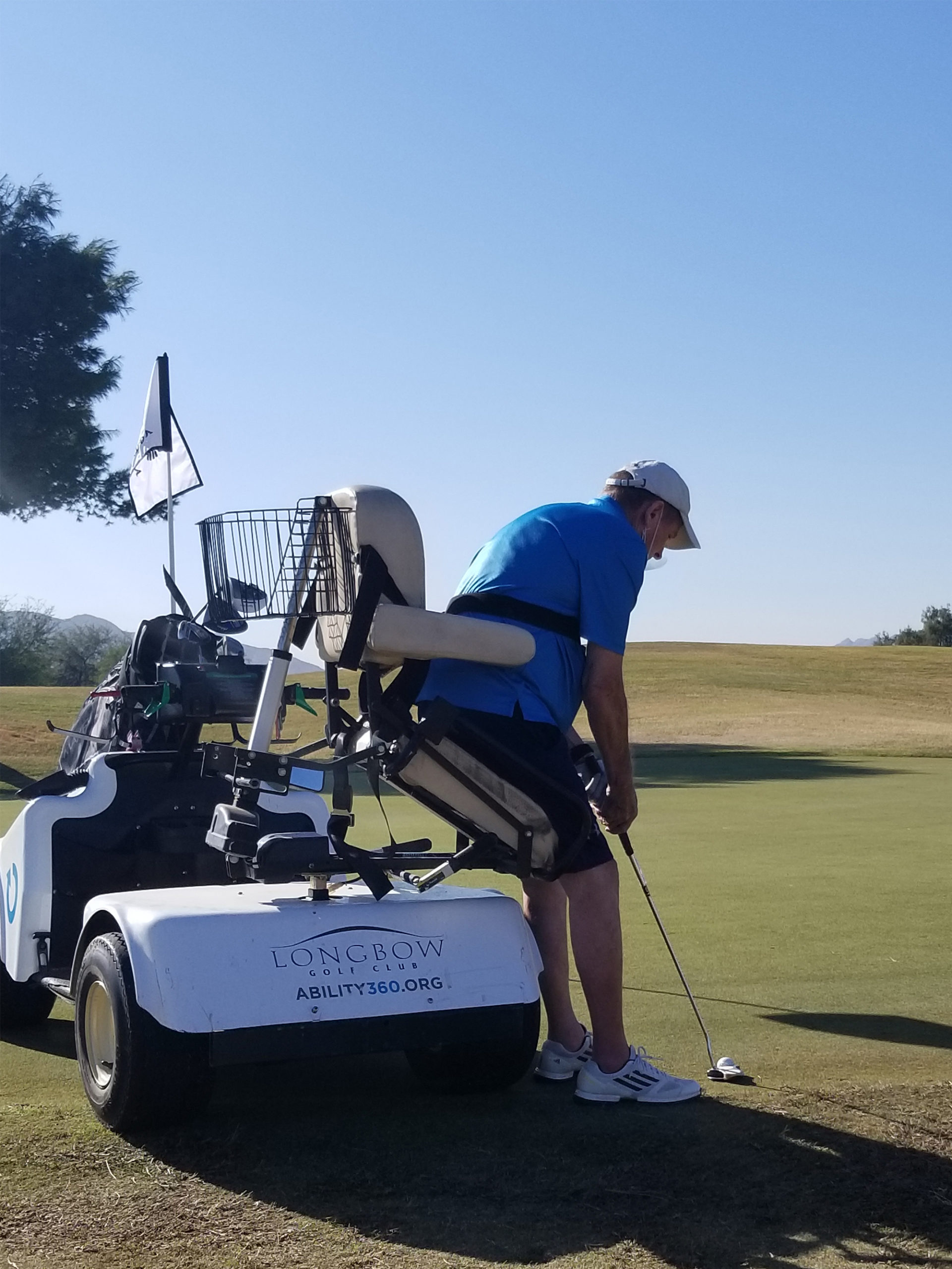 Male athlete golfing using a golfing power wheelchair