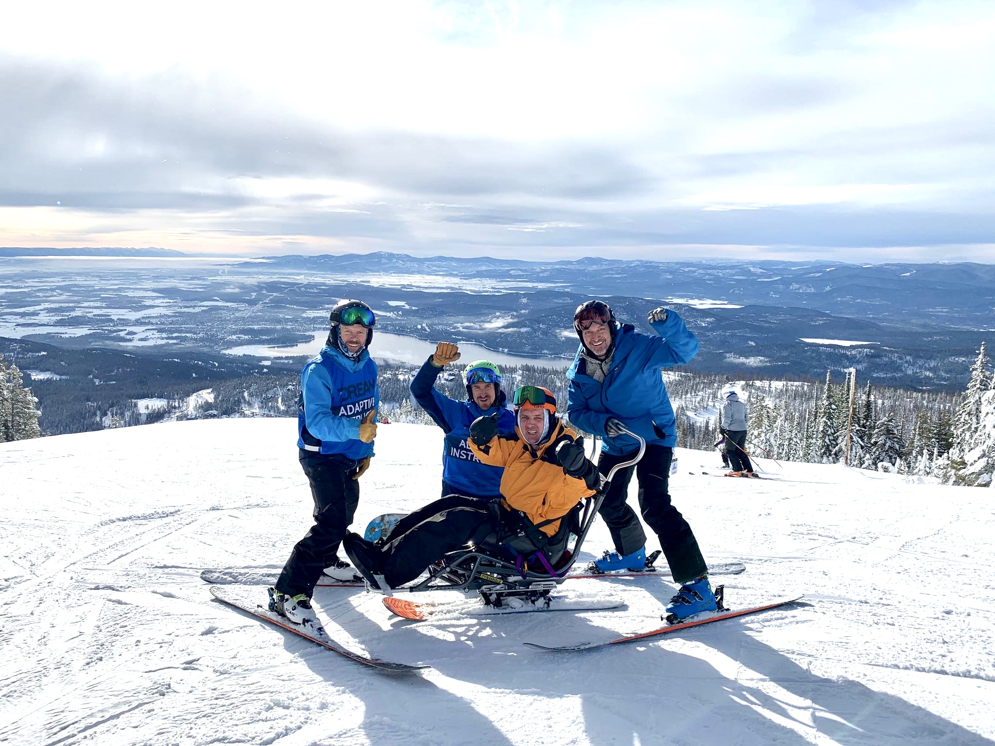 skiers (2 standing, 2 sitting) on mountain