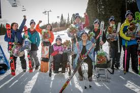 Athletes posed for a picture holding various snow equipment