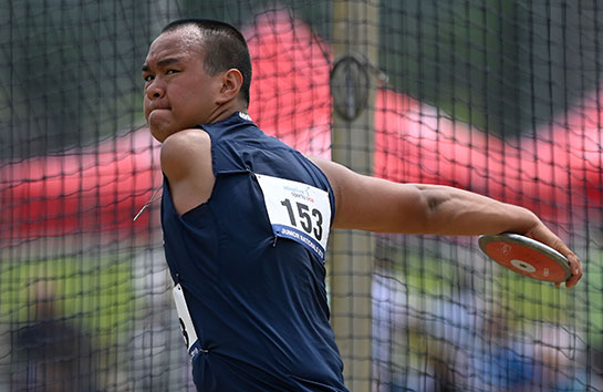 Male athlete with left arm amputation throwing a discus