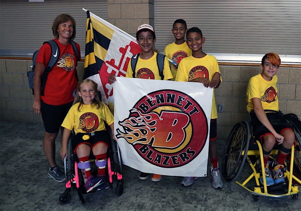 Group of young athletes posed for a group picture holding a bennett blazers banner