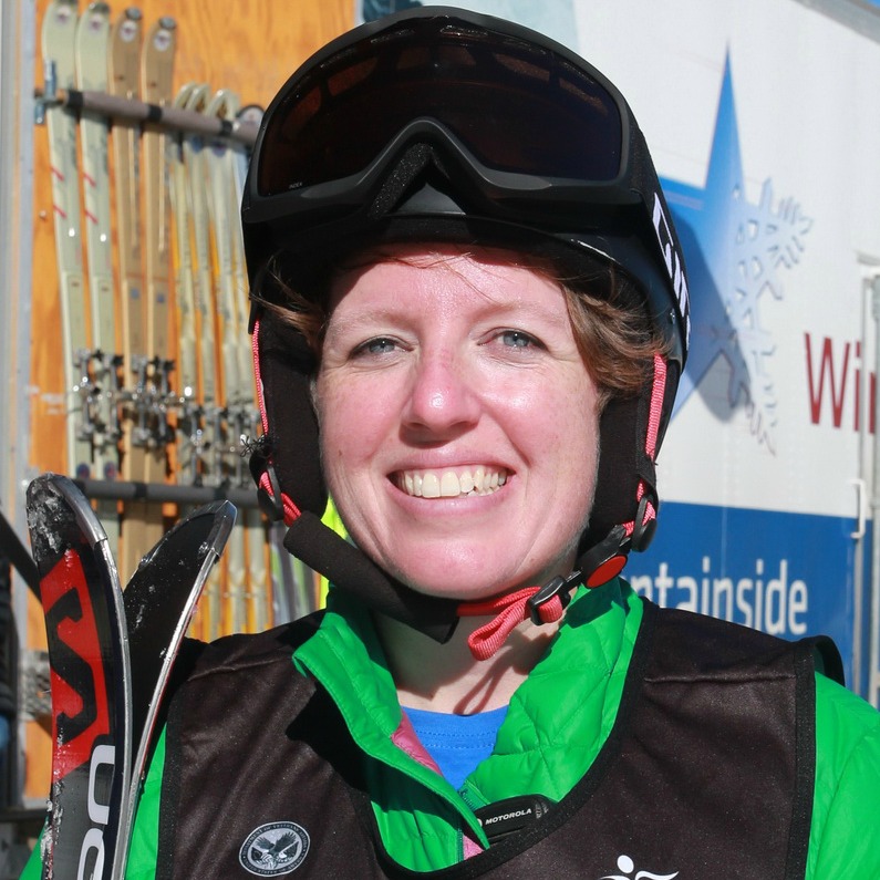 Female with ski equipment smiling at the camera