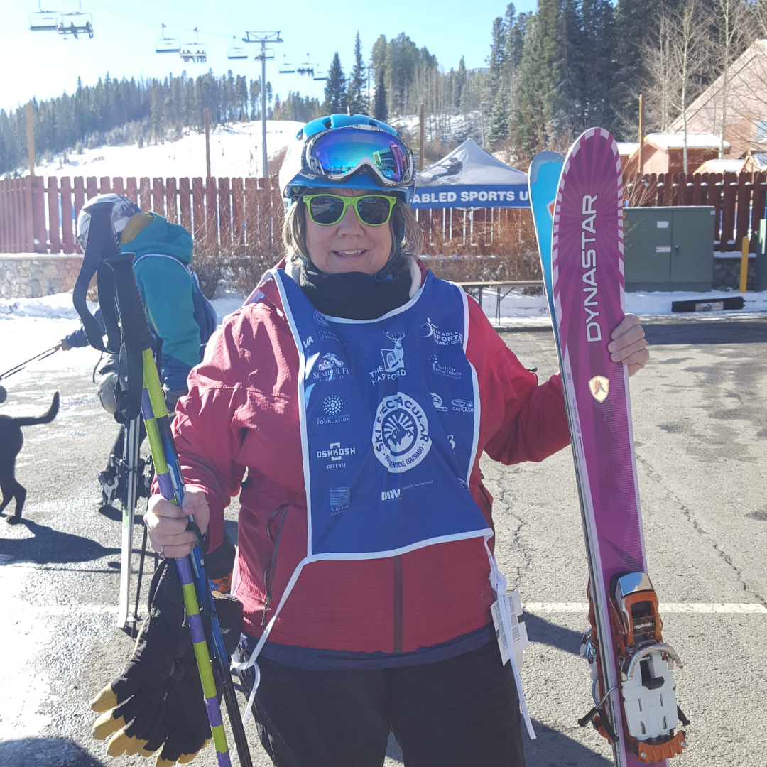 Ski Spec athlete holding ski equipment and smiling at camera