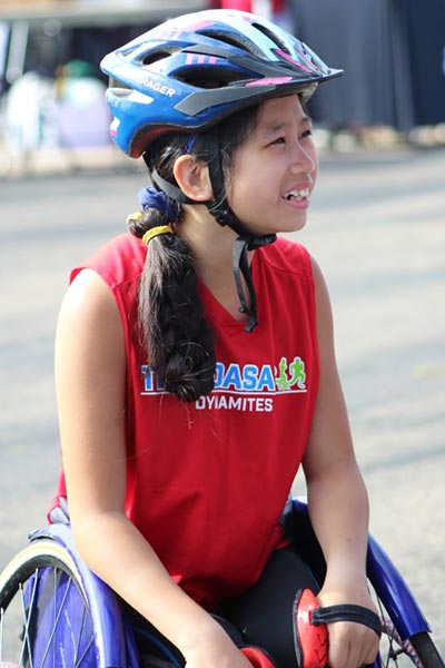 Female athlete in a wheelchair smiling