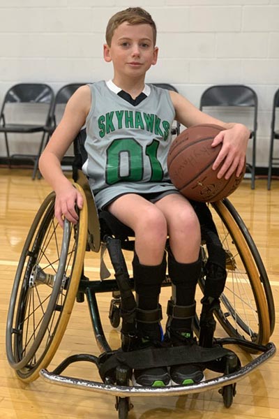 Male athlete sitting in wheelchair with basketball on his lap
