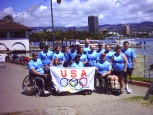 Group on dock near water holding a USA banner