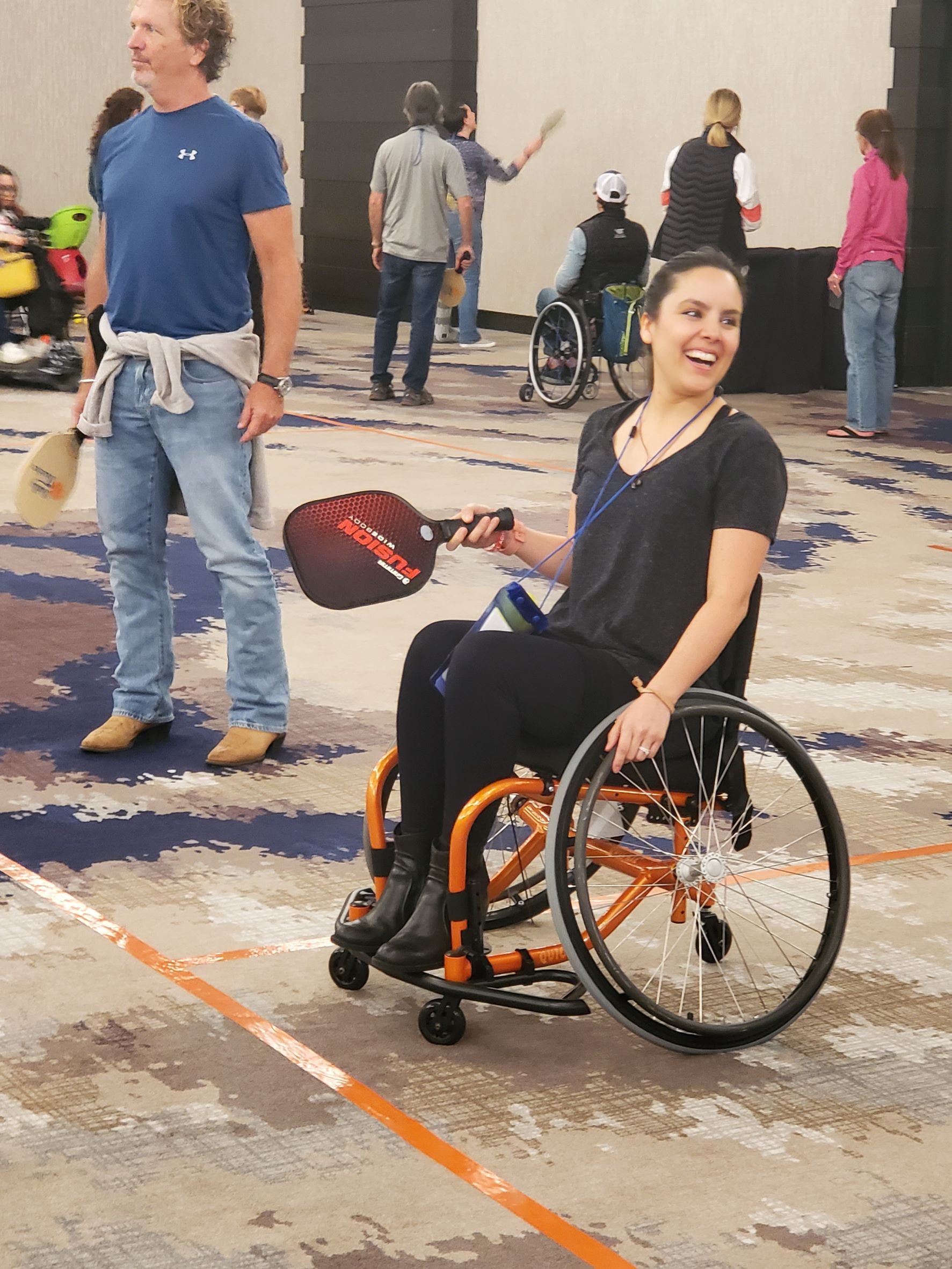 Female athlete smiling while in a sport chair playing pickleball