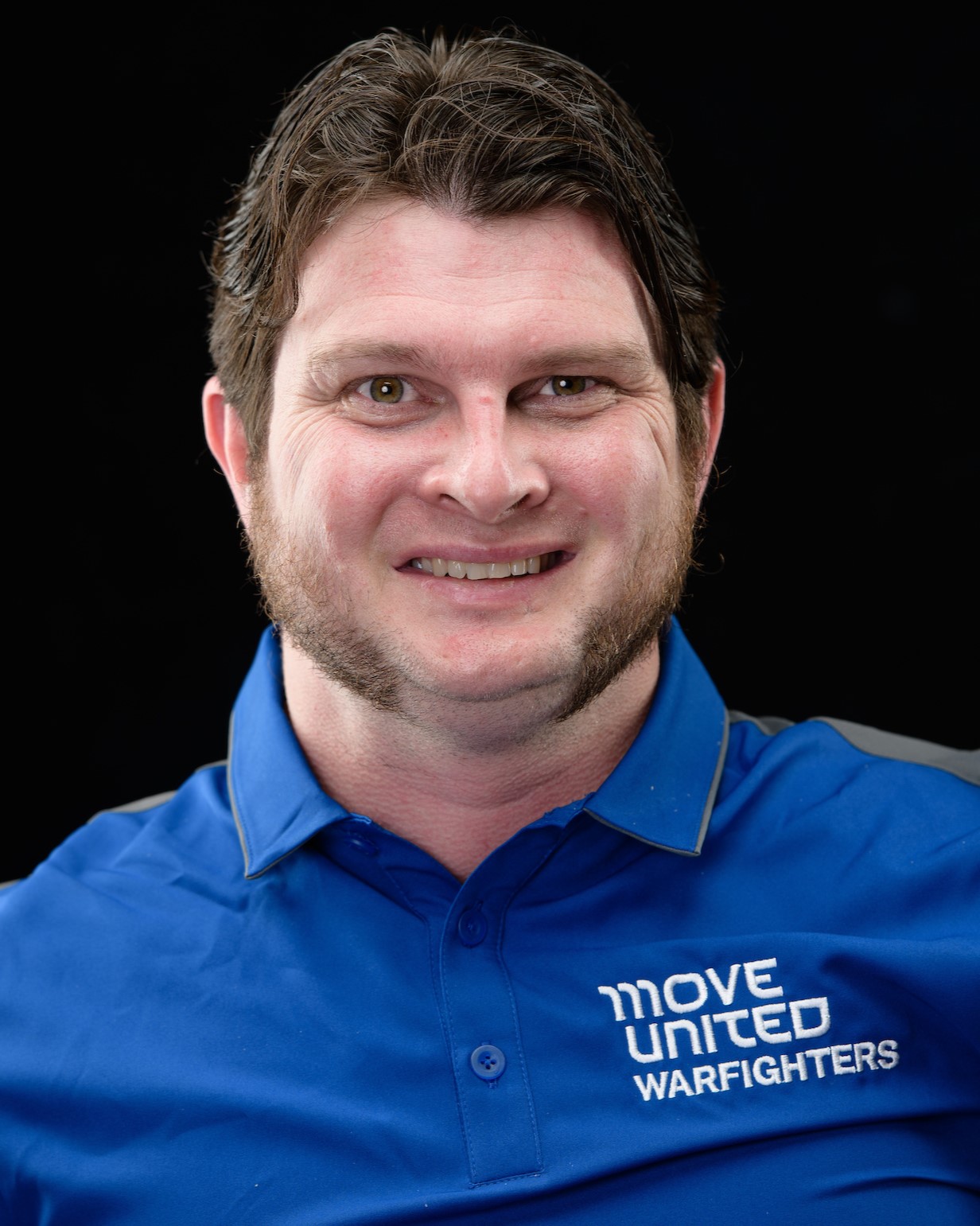 Headshot of Timothy Brown wearing a blue Move United Warfighters polo in front of a black background.