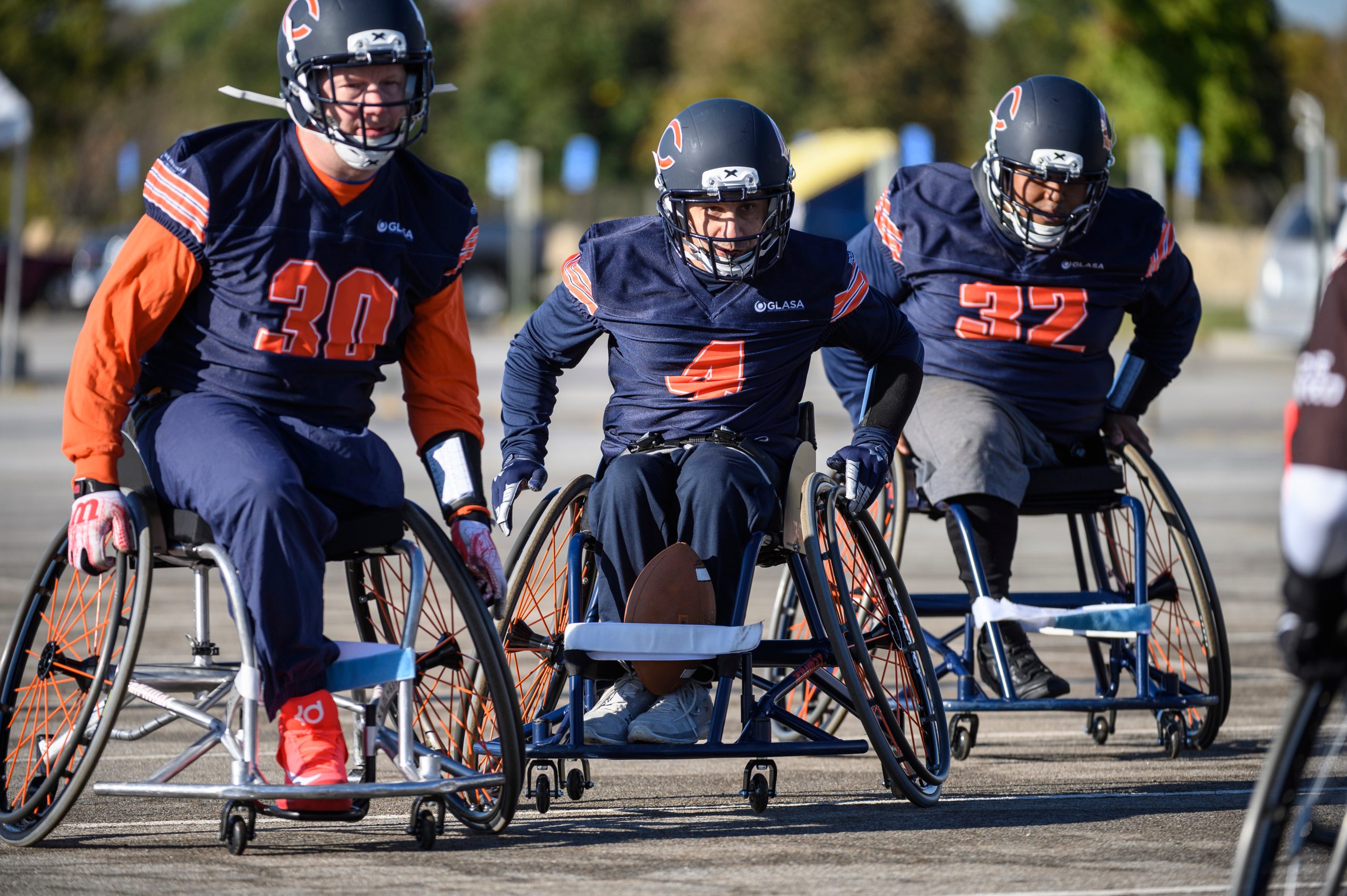 Three people playing wheelchair football