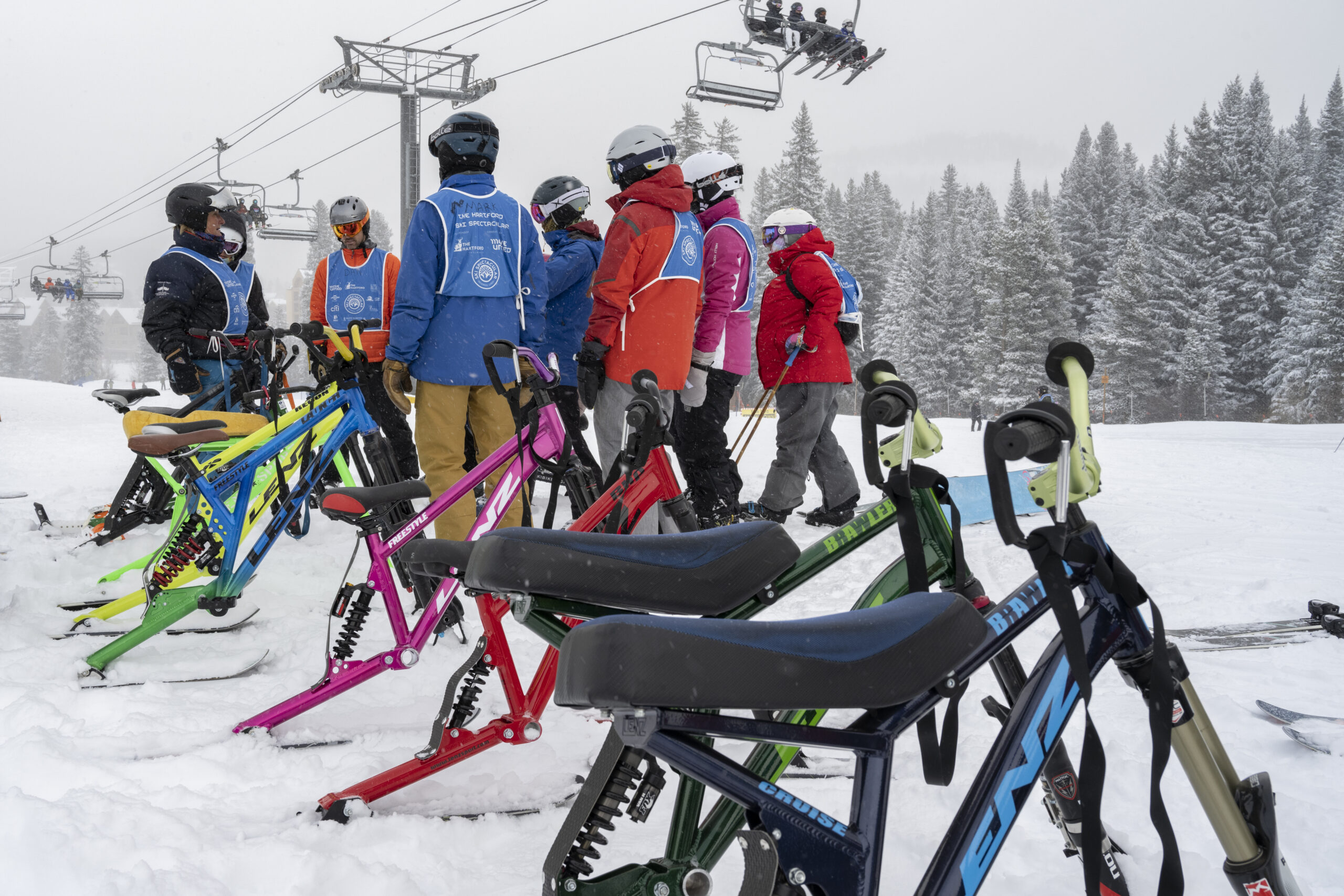 Group of people standing at the top of a ski hill