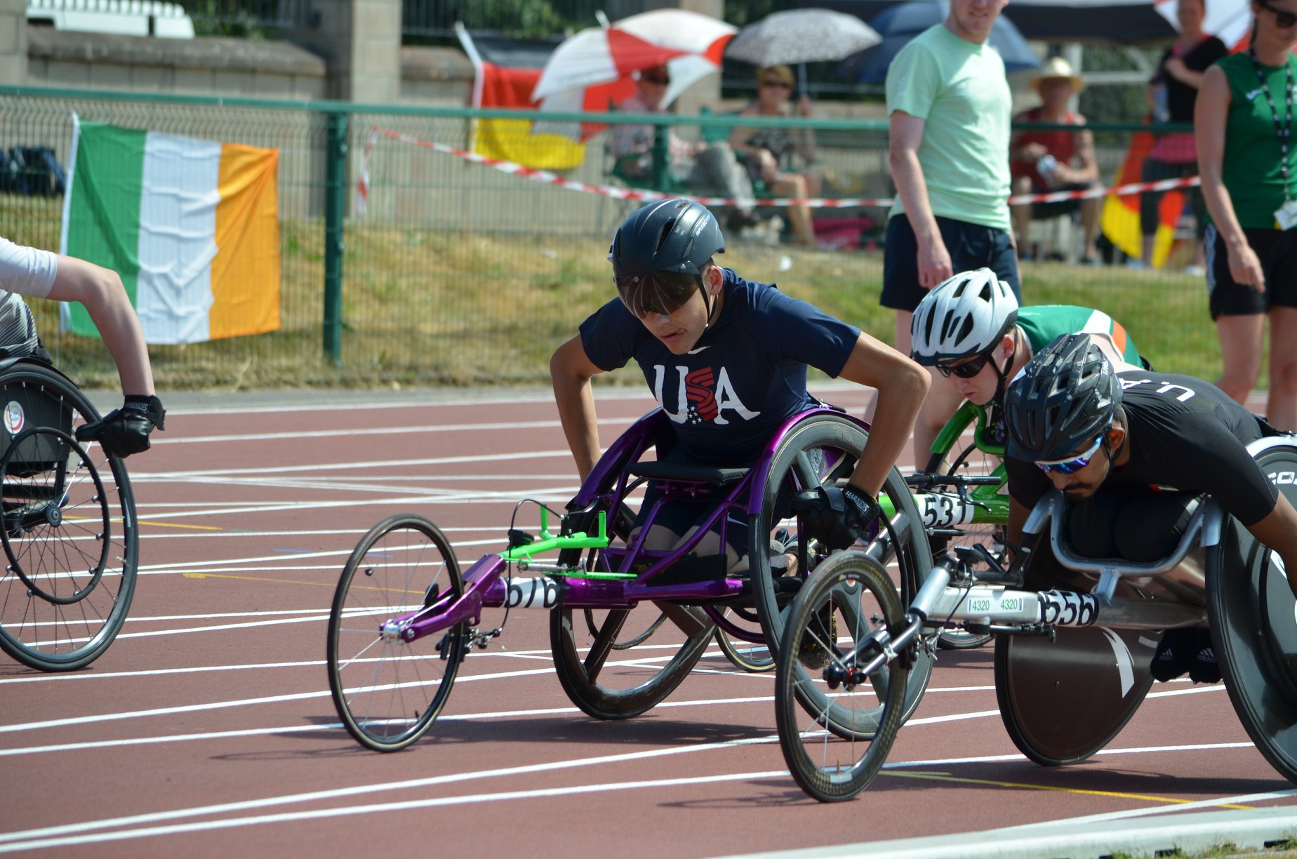 Group of people participating in wheelchair racing on an outdoor track