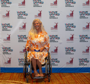 Jaqui in a wheelchair posing with her award
