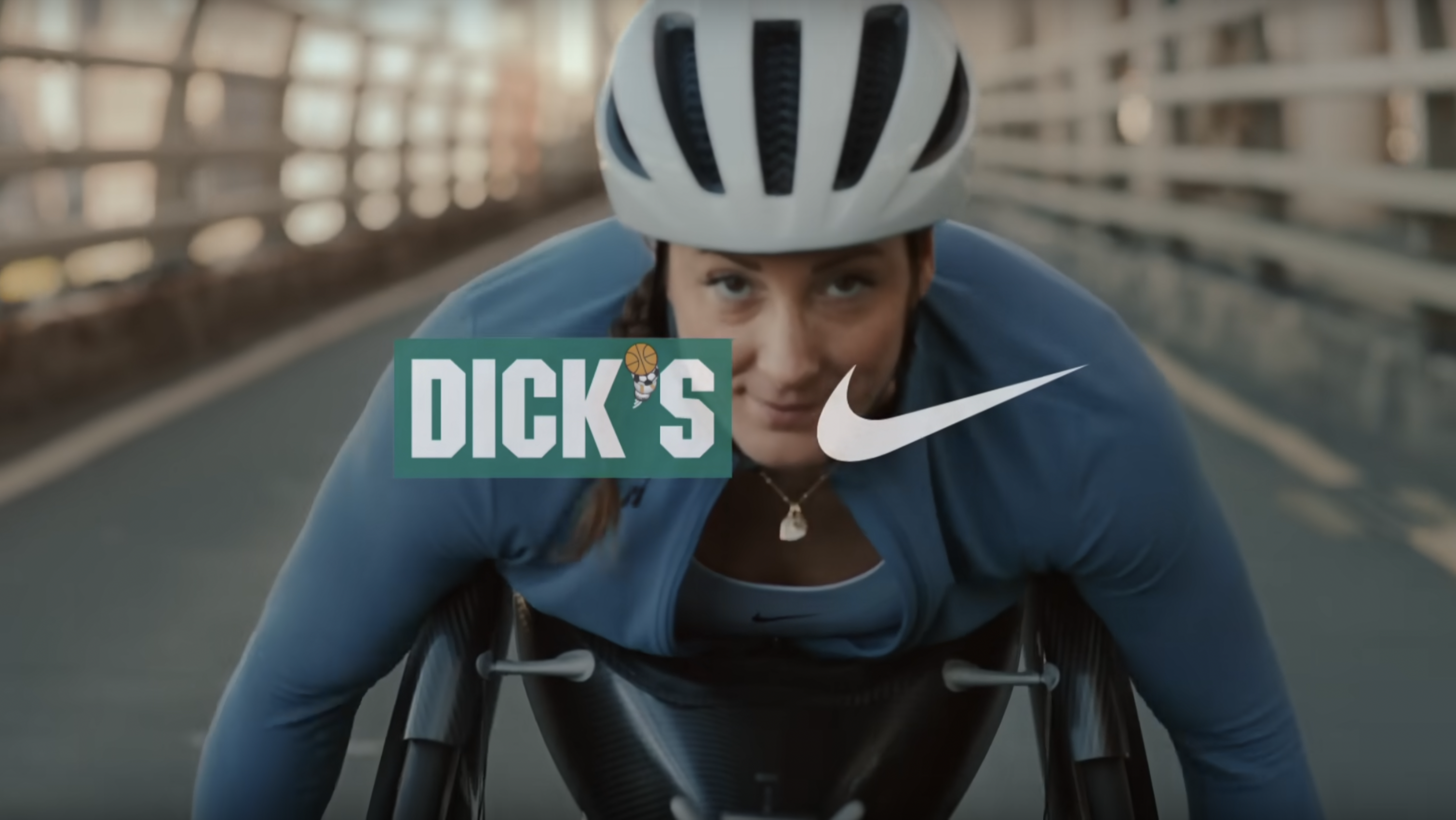 Tatyana McFadden riding a racing wheelchair towards the camera with a Dick's Sporting Goods and Nike logo in the center of the video