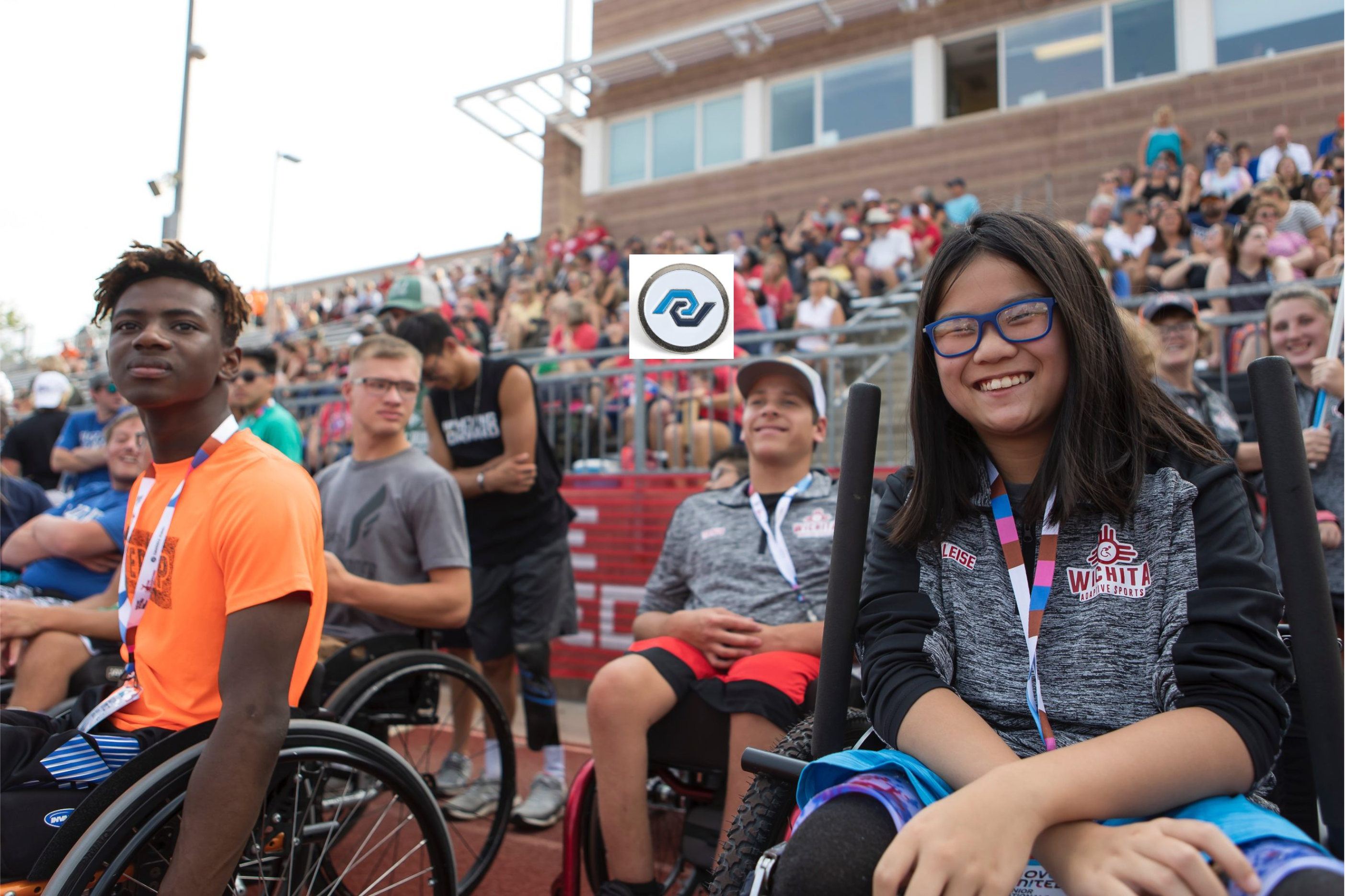 Youth adaptive athlete smiling looking at camera in the stands at an event.