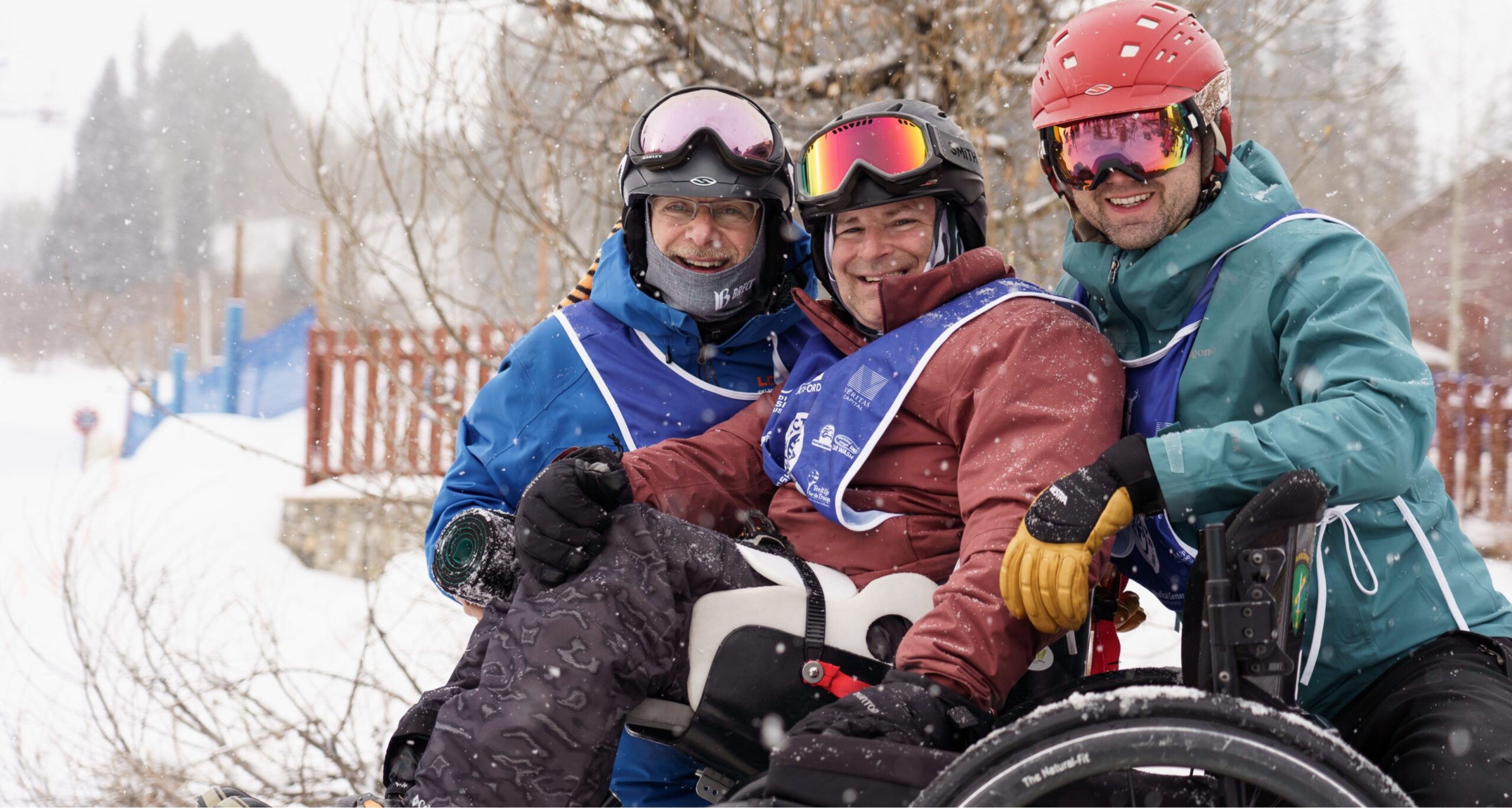 Three skiers smiling at camera on snow