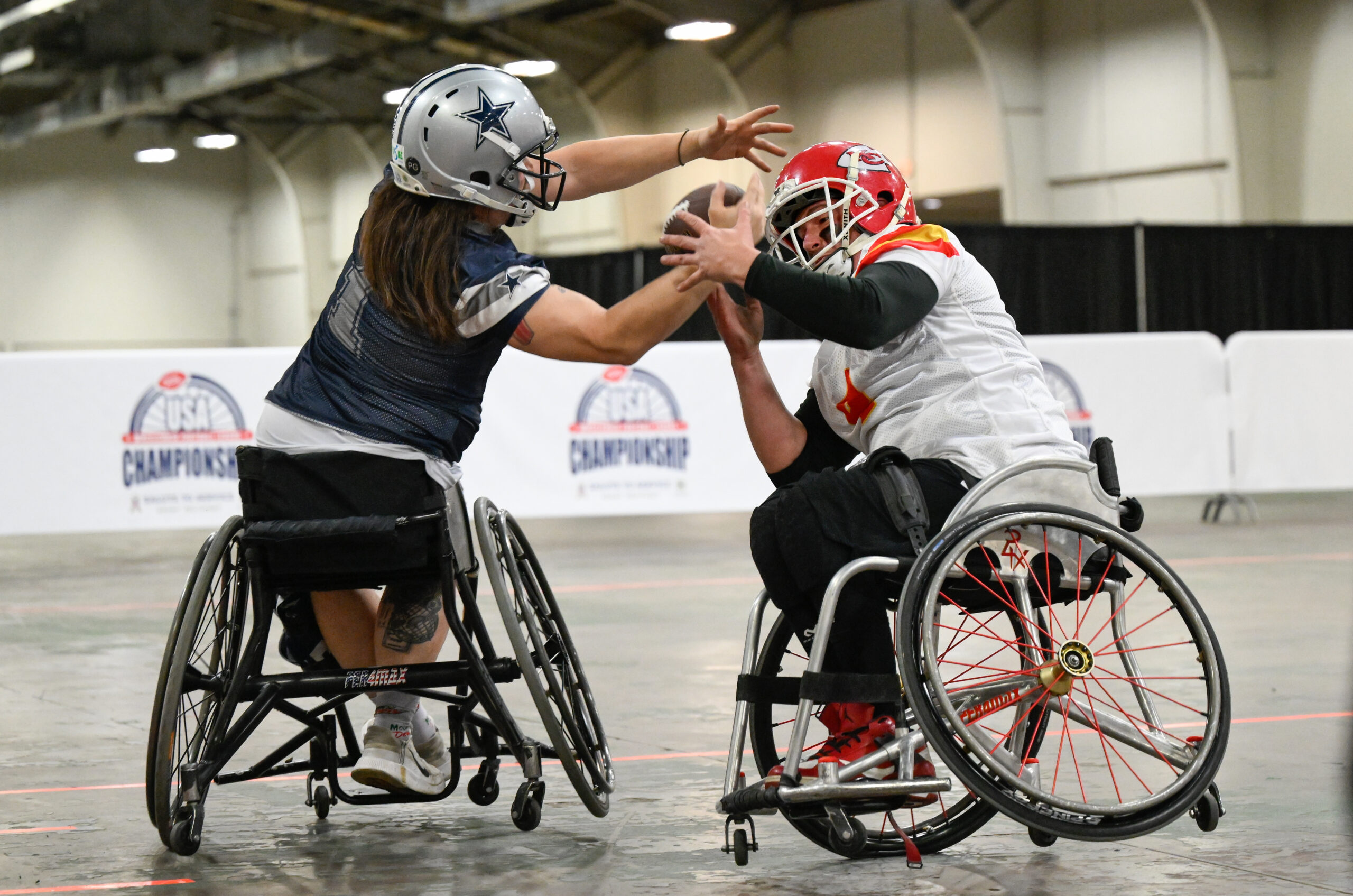 Dallas Cowboys player Zach Blair, left, pulls a pass away from Kansas City Chiefs player Matt Bollig for a touchdown during the USA Wheelchair Football League Championship, a program of Move United, Tuesday, Feb. 6, 2024 in Dallas, TX. (Photo by Reed Hoffmann for Move United)