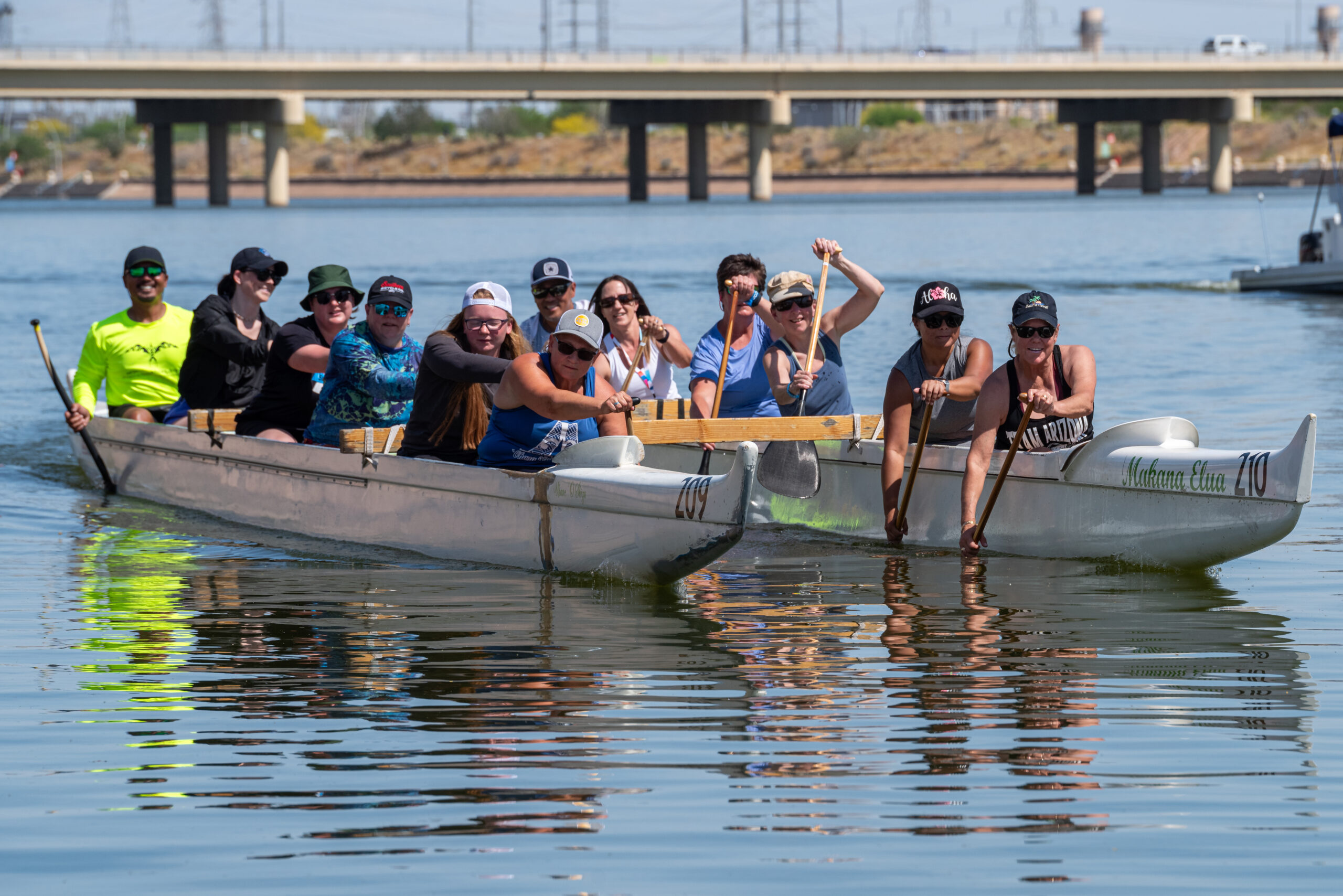 2 groups of 5 athletes each in outrigger canoes paddling towards the viewer