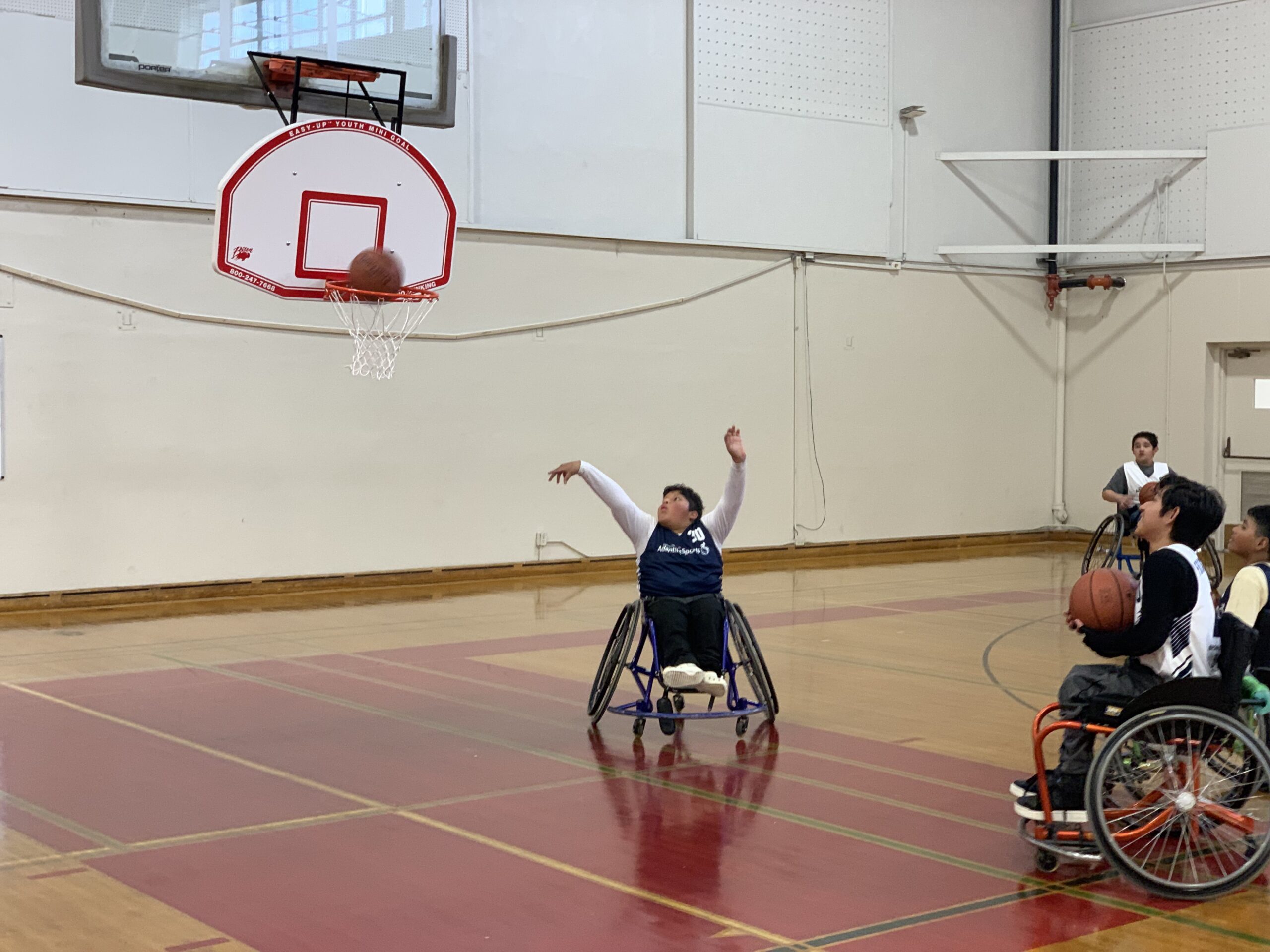 A wheelchair basketball player takes a shot.