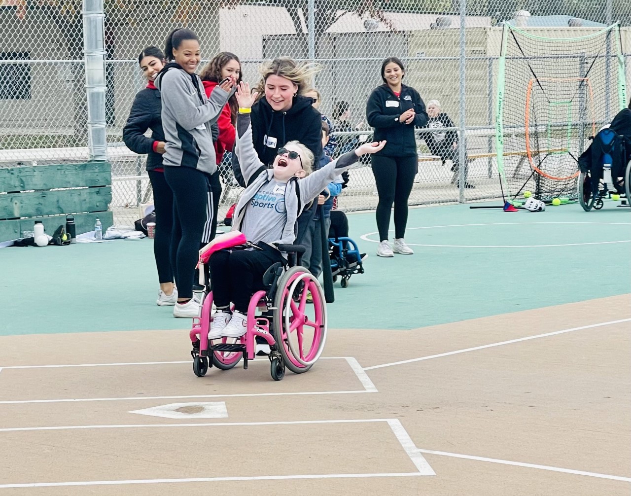 A person in a wheelchair cheers as she is wheeled to homebase.