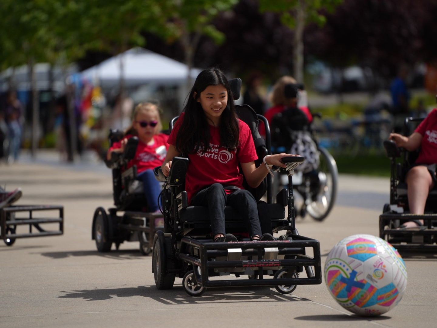 An athlete in a power wheelchair goes after a power soccer ball.