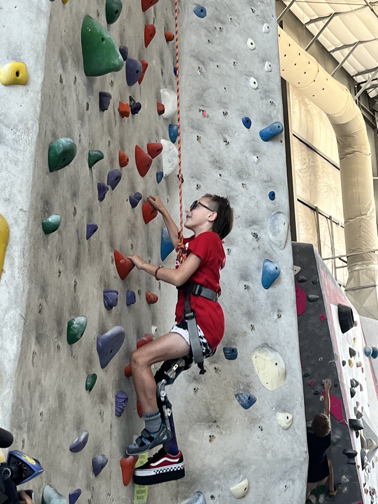 A athlete climbs up an indoor rock wall.