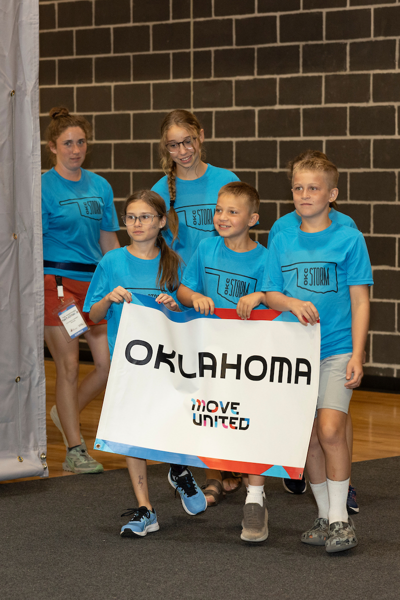 Athletes holding Oklahoma banner marching into Welcome Ceremony at The Hartford Nationals.