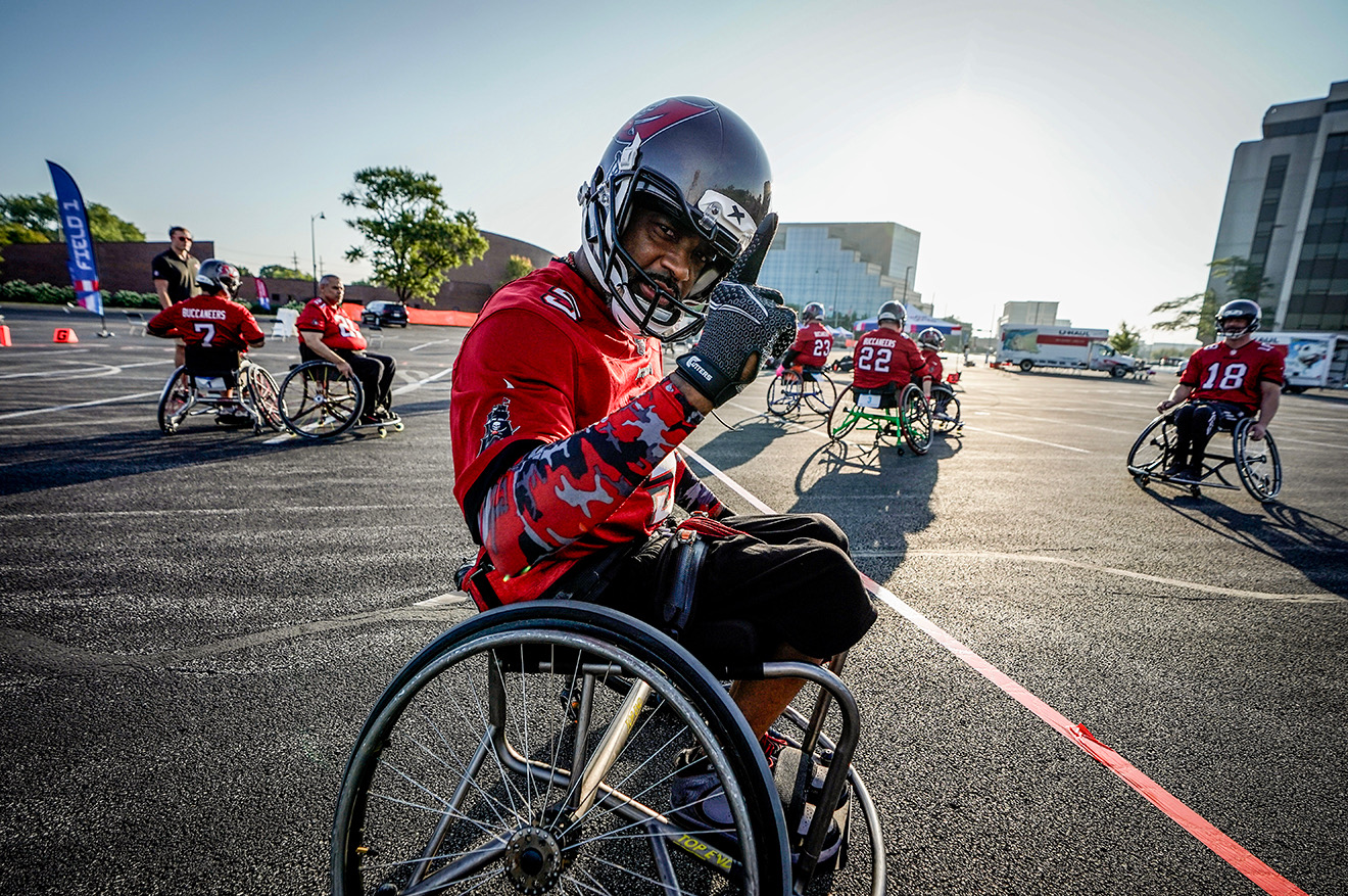 Tampa Bay Buccaneer Wheelchair Football Team athlete posing at the camera with thier fist in the air