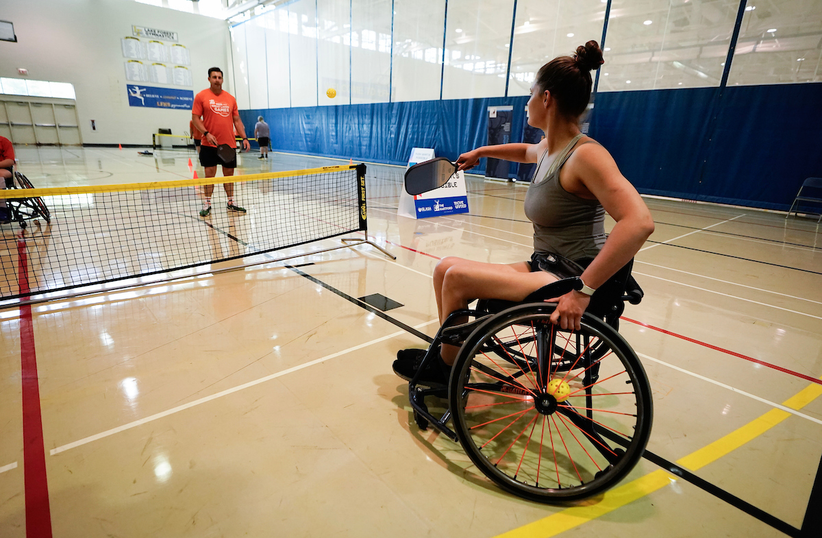 Two athletes on court hitting ball to one another in pickleball match