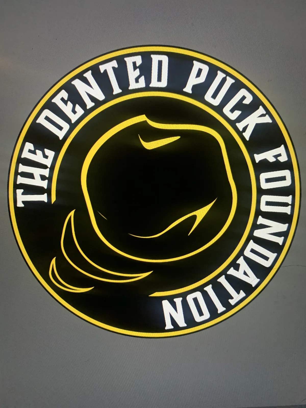 The Dented Puck Foundation Logo